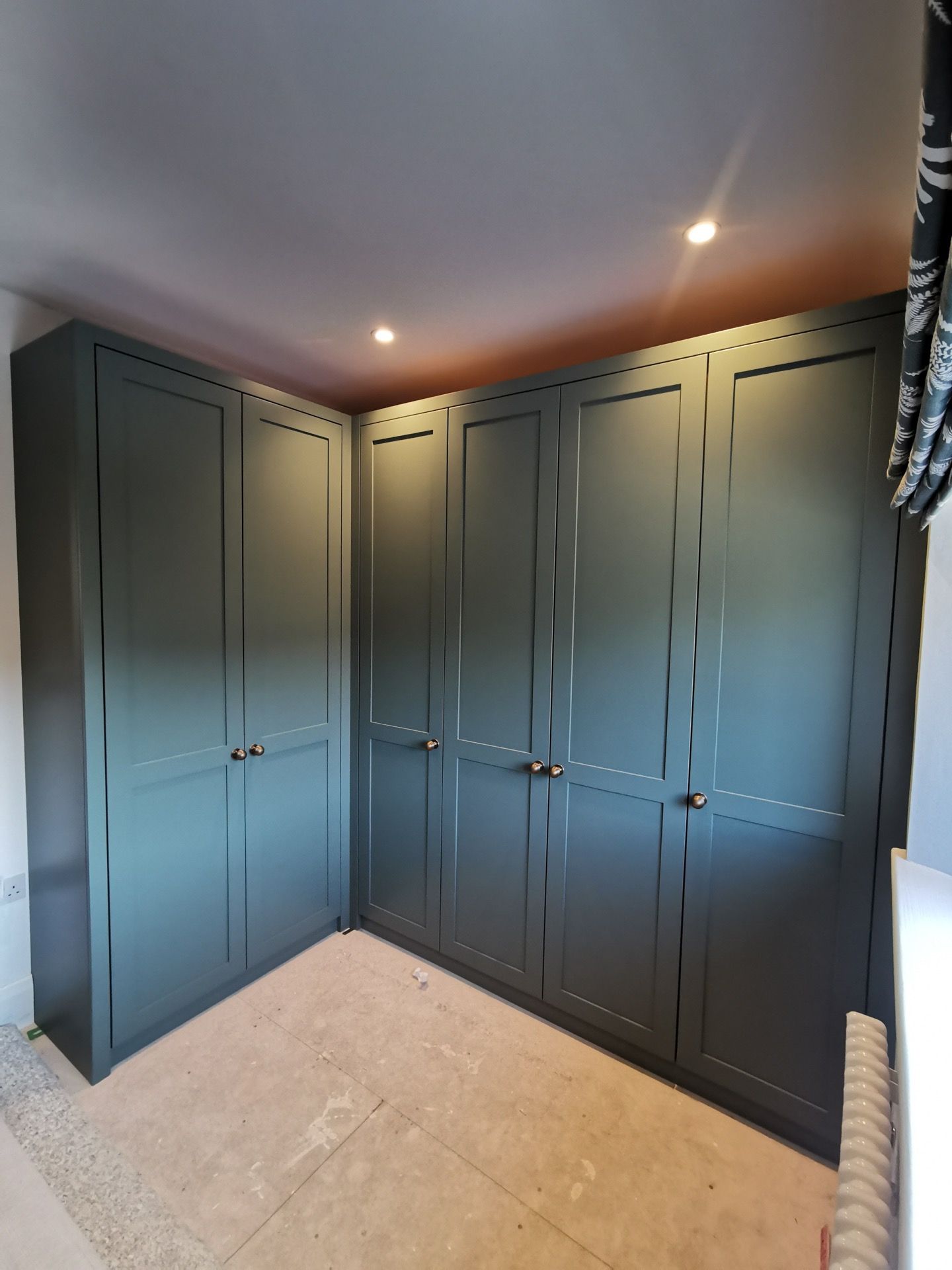 A pink fitted wardrobe with Cane webbing panelled doors.
