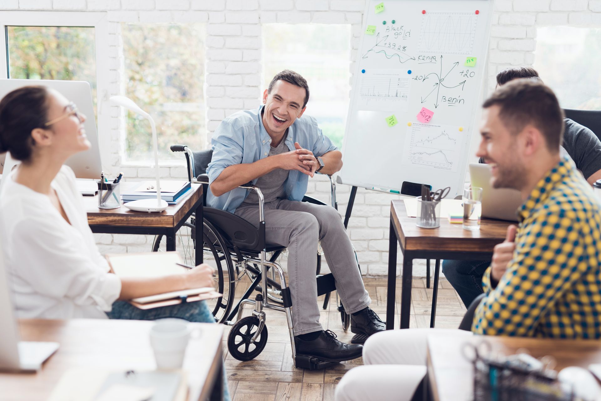 A man in a wheelchair is sitting at a table with other people.