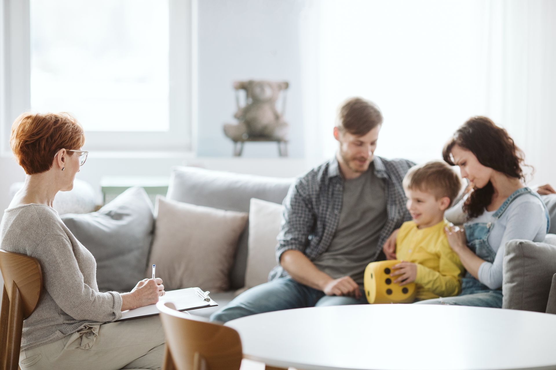 A family is sitting on a couch talking to a female counselor.