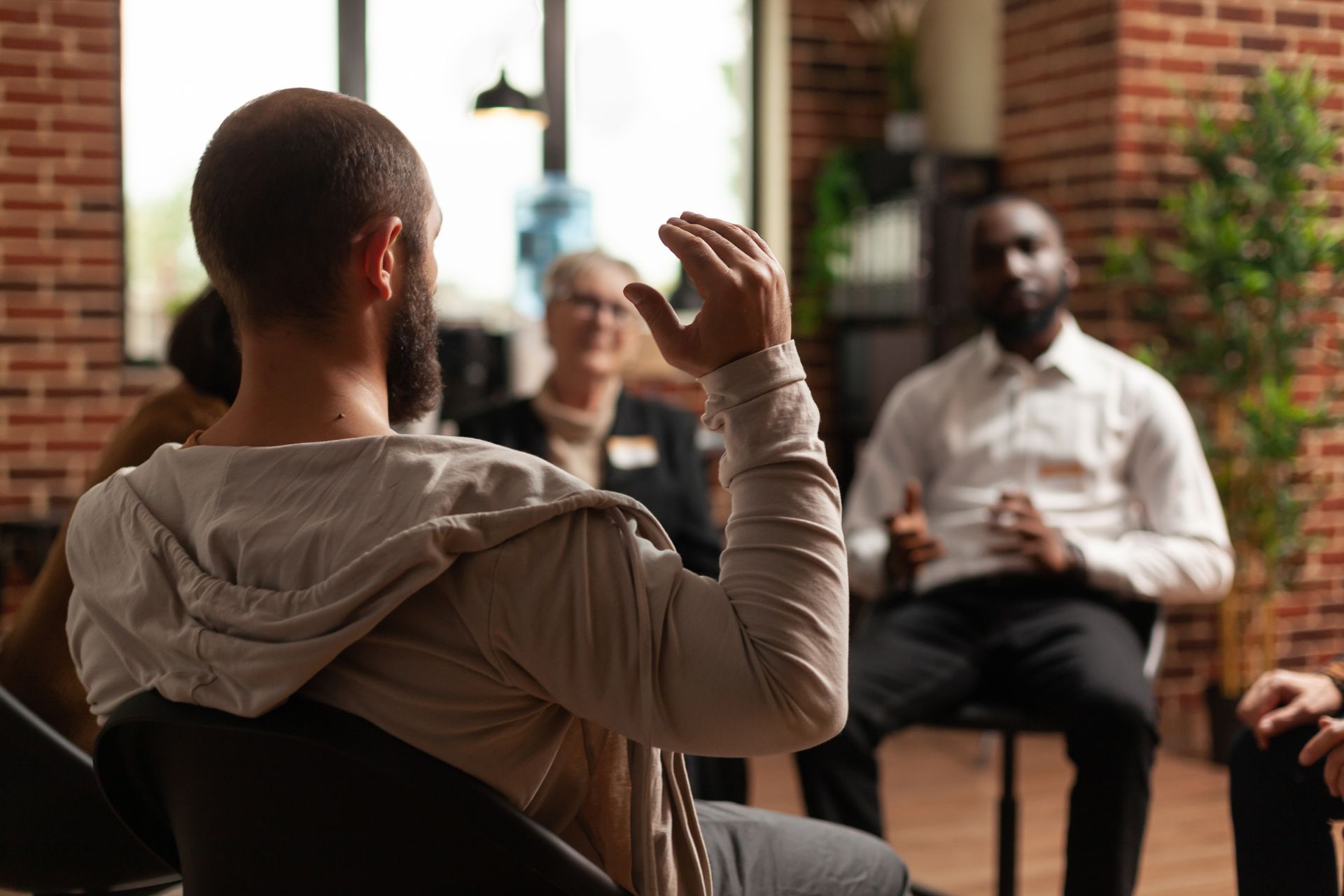 A man is sitting in a chair talking to a group of people.