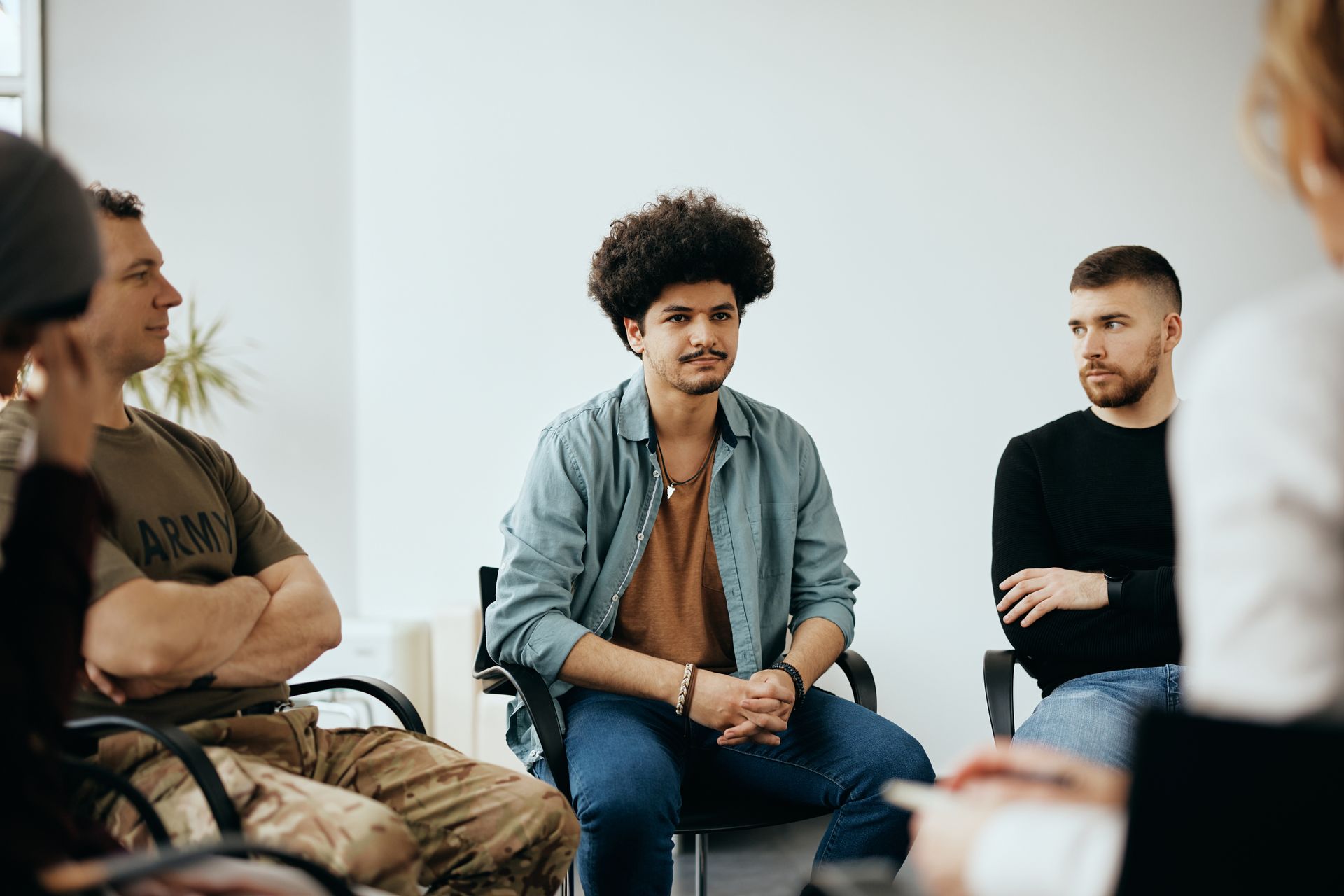 A group of people are sitting in a circle talking to each other.