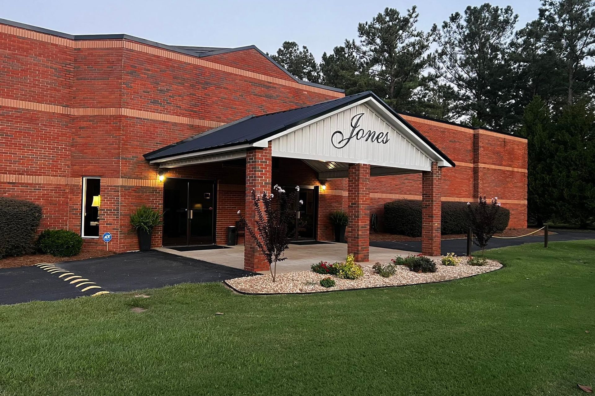 A large brick building with a porch and a sign that says jones
