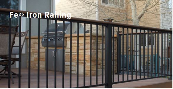 Black iron railing along a brick sidewalk in front of a building with stone steps