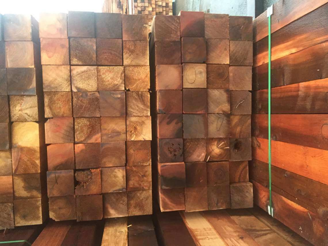 Stacked wooden blocks in a storage area, lit by warm sunlight.