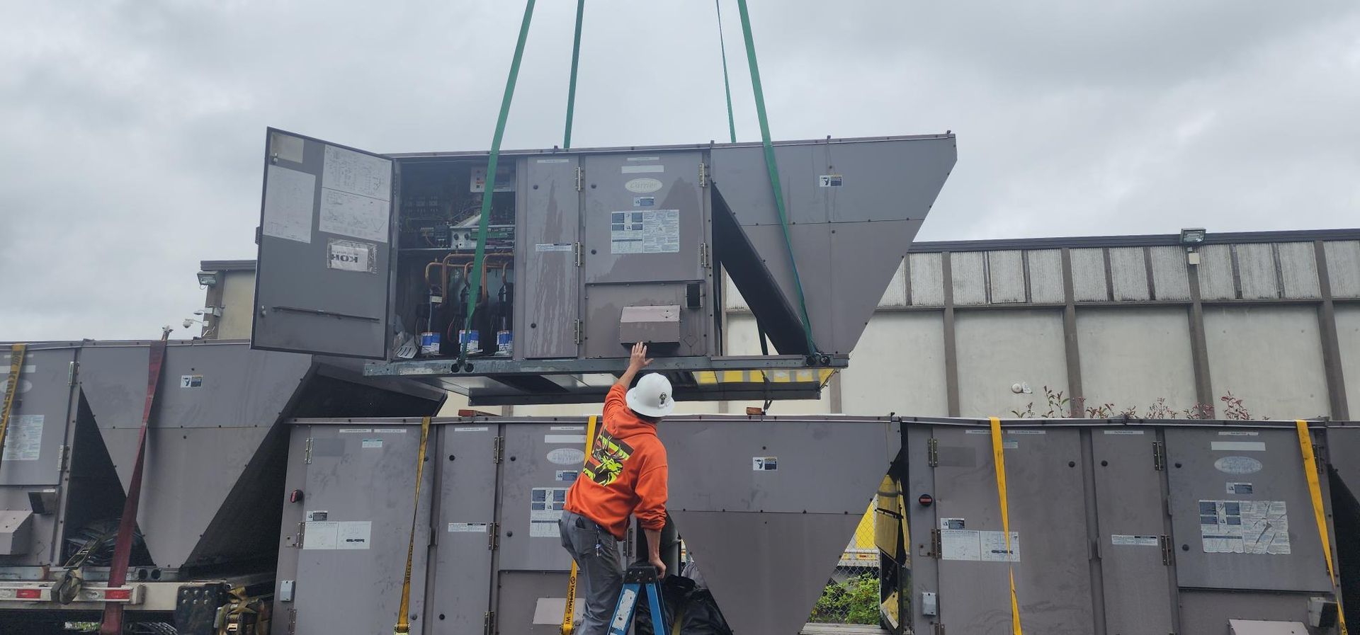 A crane is lifting a large container from a train car.