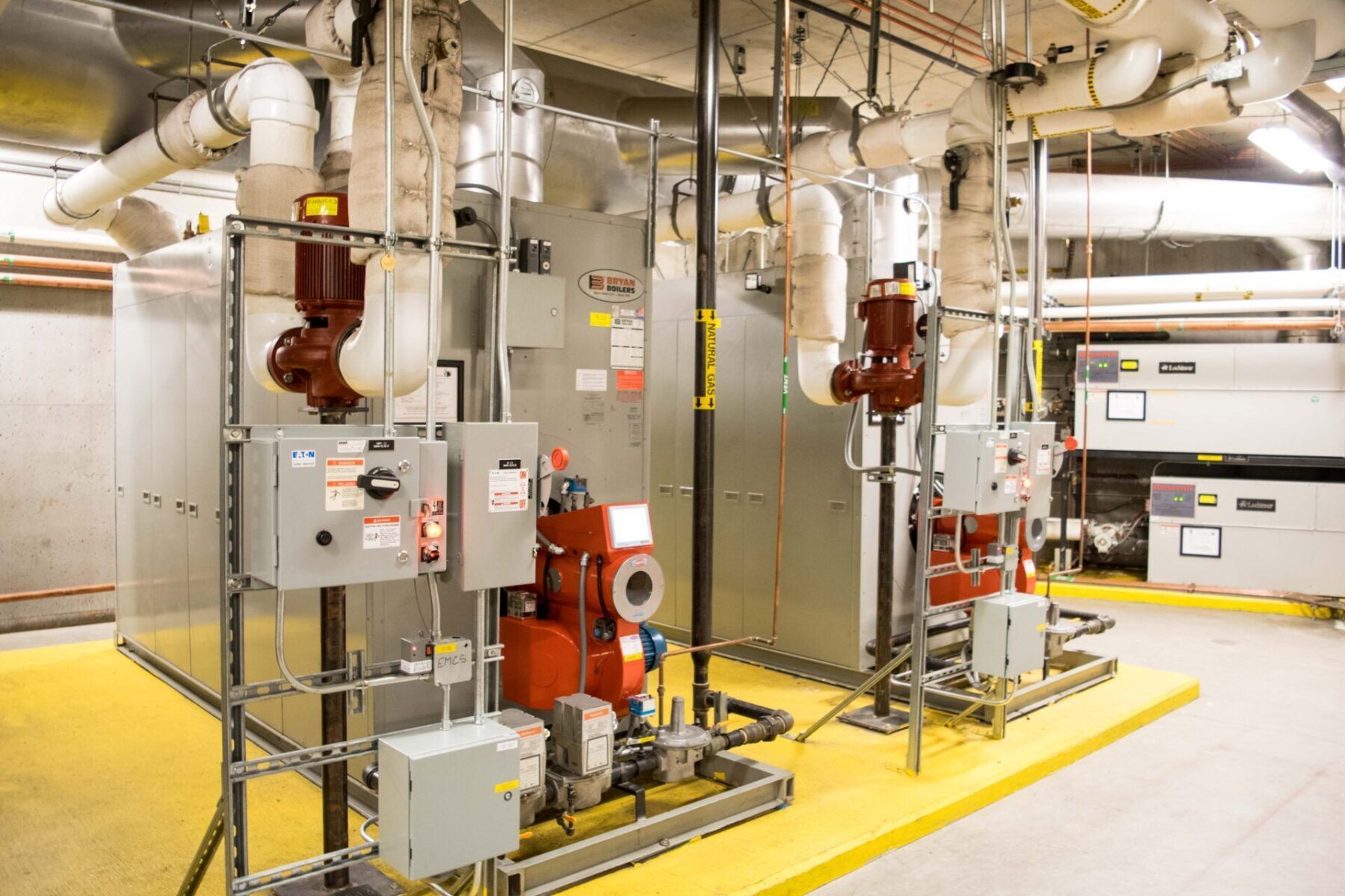 HVAC equipment in an industrial setting, featuring pipes, valves, controls, and a yellow platform.