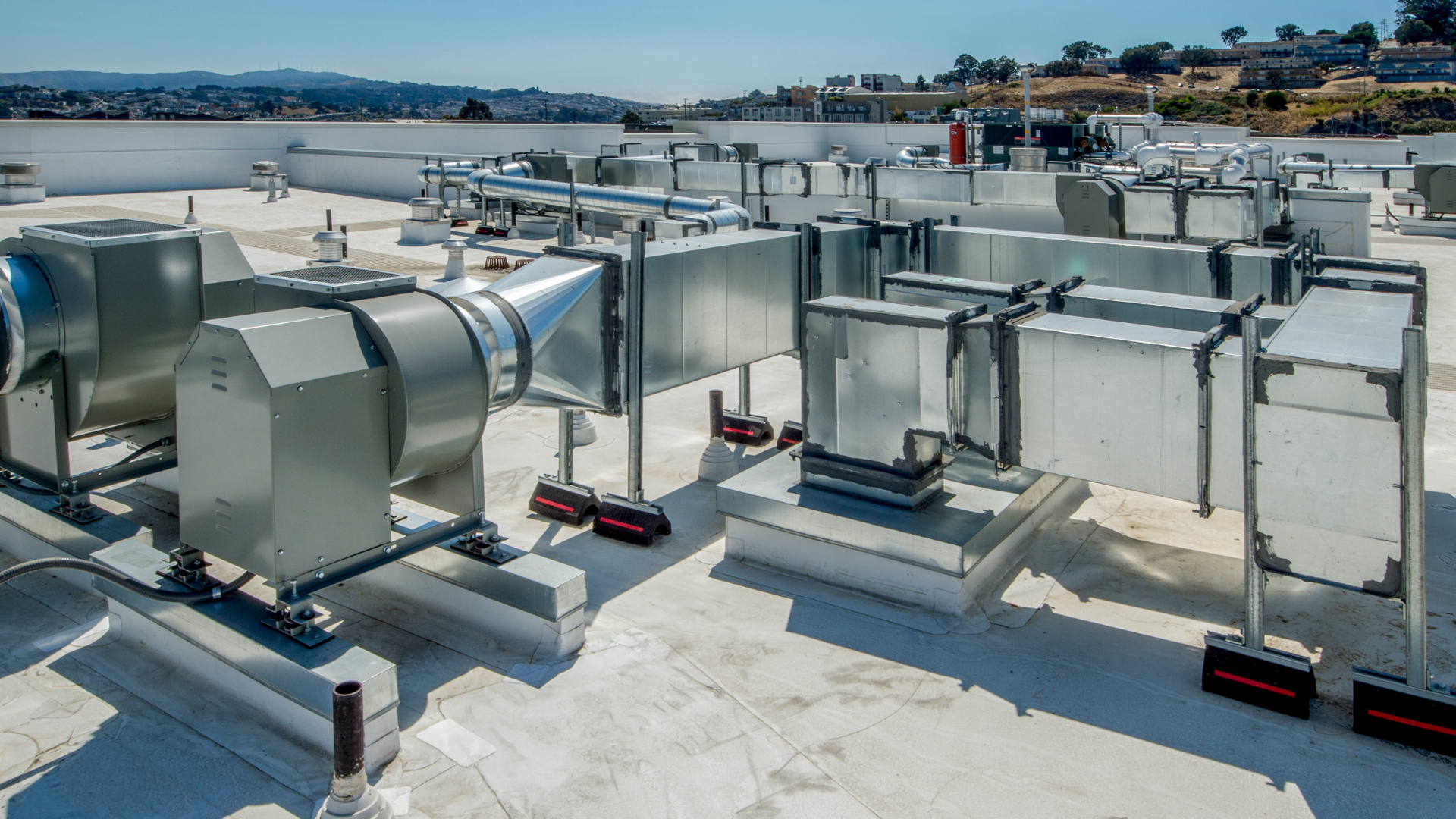 A rooftop with a lot of ventilation pipes on it.