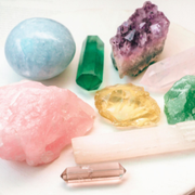 Assorted colorful crystals and polished gemstones arranged on a white surface