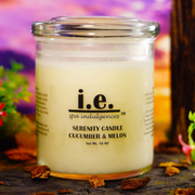 Glass candle labeled “i.e.” Serenity Candle Cucumber & Melon on a colorful floral background