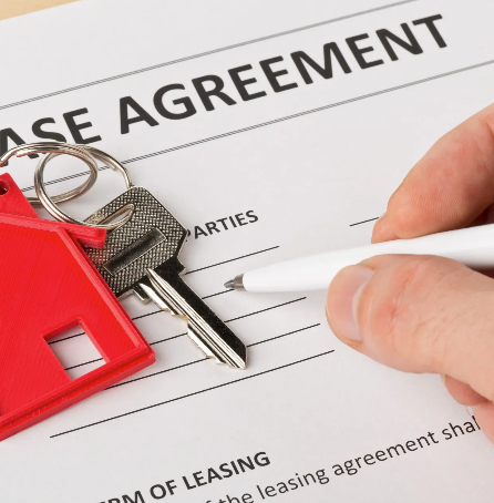 A person is signing a leasing agreement with a pen