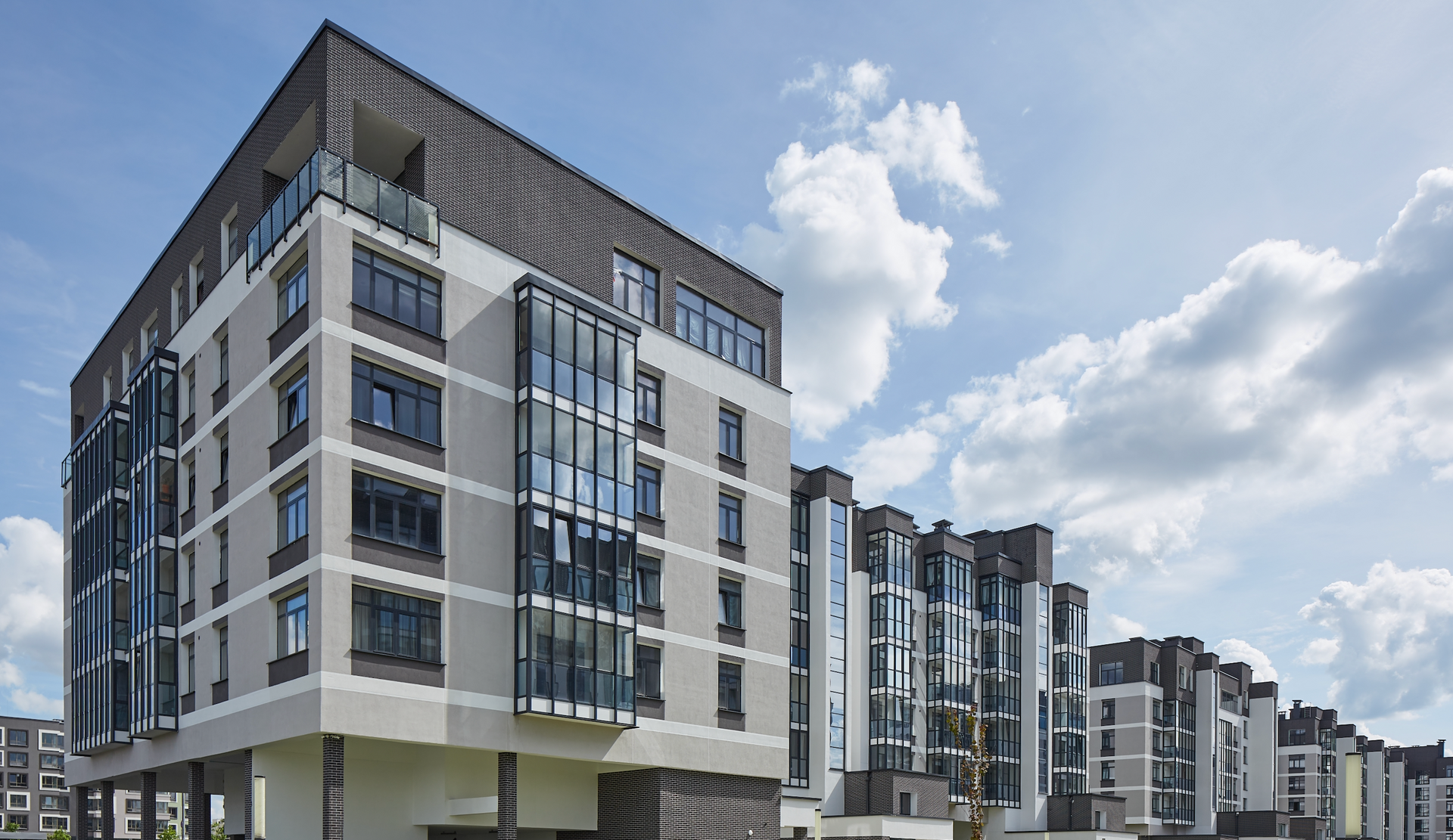 A large apartment building with a lot of windows on a sunny day.