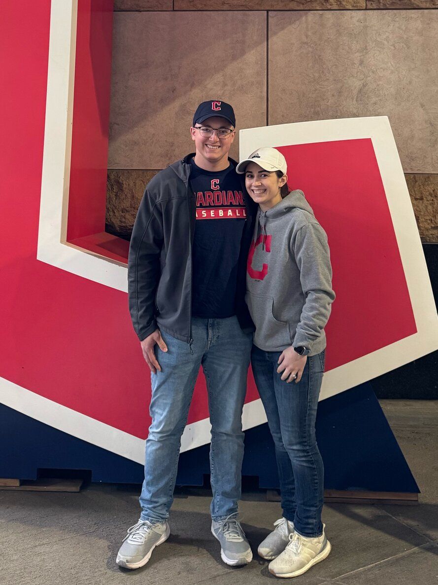 A couple poses in front of a giant red and white