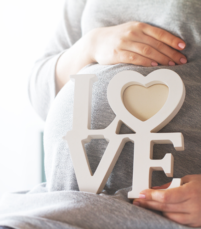 Pregnant woman holding a white 