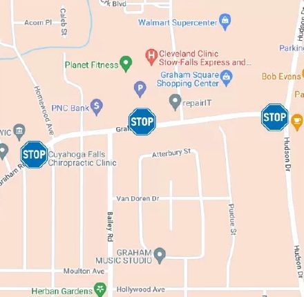 Map with stop signs, businesses like Planet Fitness and Walmart, and street names.