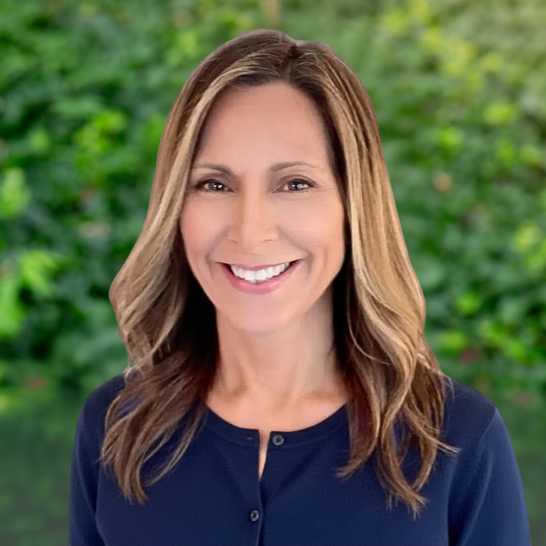 Woman with brown hair, smiling in blue sweater.
