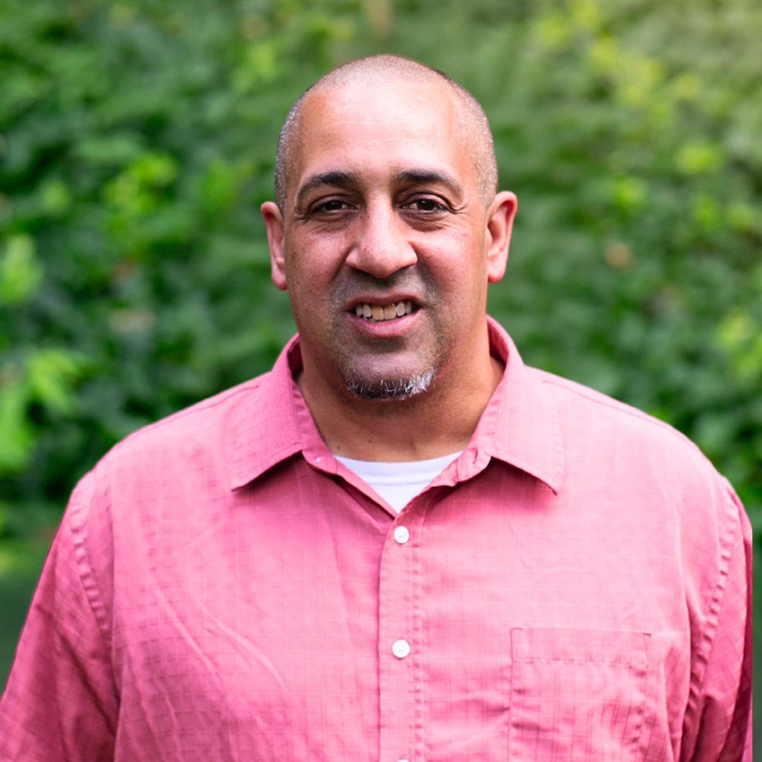 Man smiling, wearing a black shirt with 