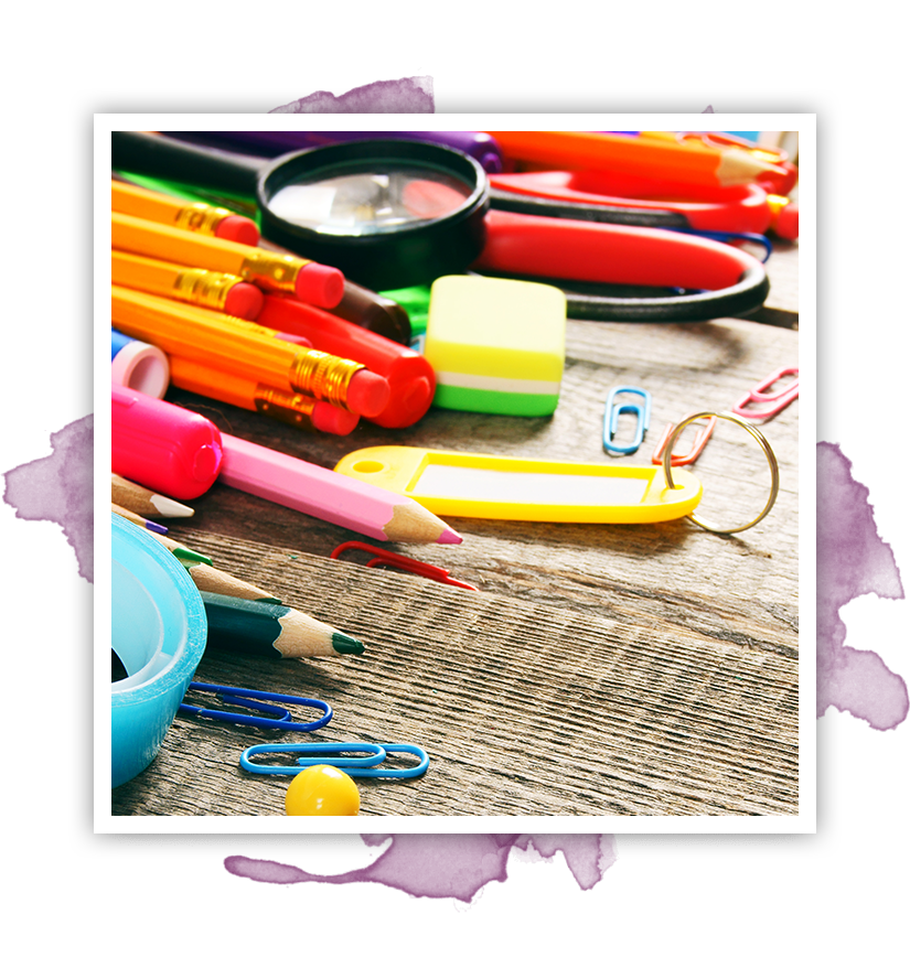 School supplies on a wooden surface, including pencils, a magnifying glass, and paperclips.