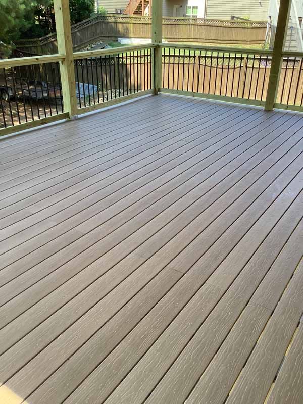 Wooden deck with angled planks, surrounded by a railing.