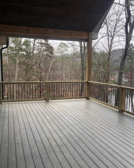 Deck with composite decking, railings, and a view of trees and a mountain.