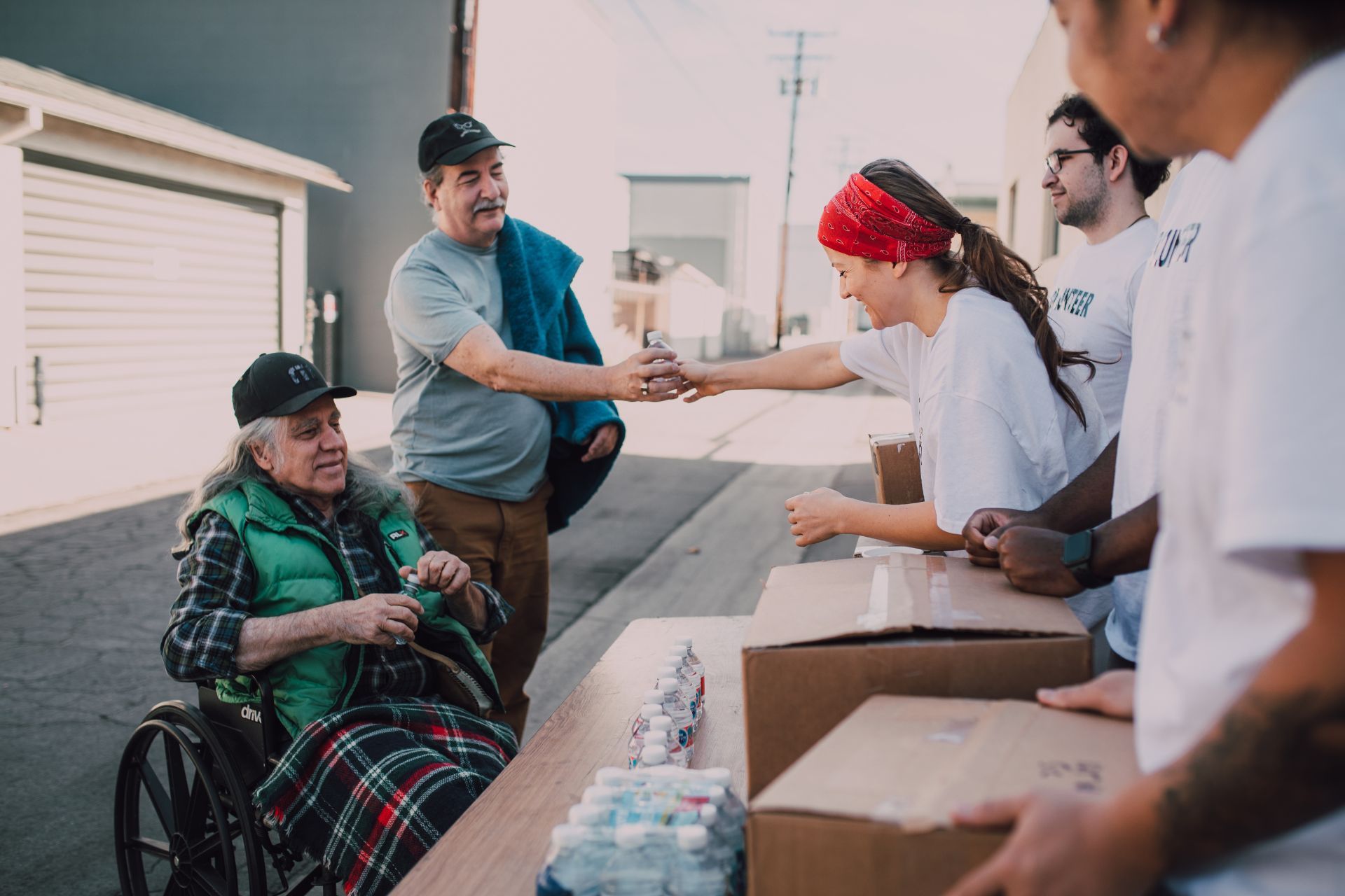 A man in a wheelchair is shaking hands with a woman.