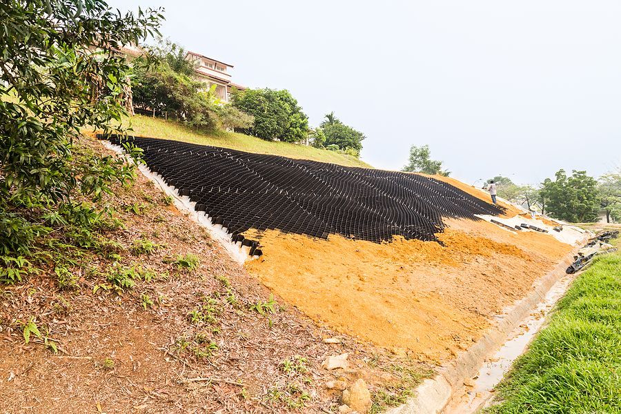 A large pile of dirt is sitting on top of a hill for erosion control..