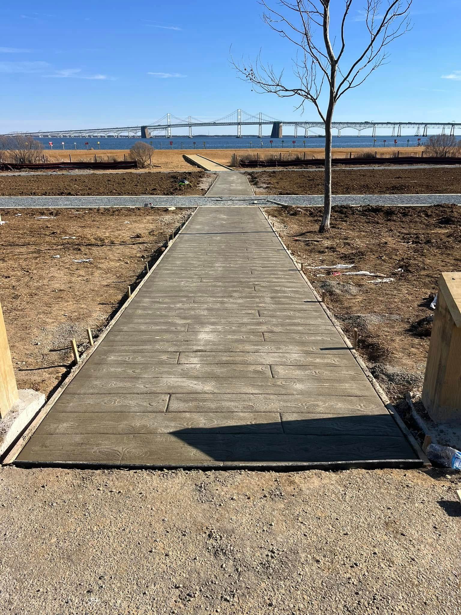 A stamped concrete walkway leading to a body of water.