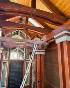 A ladder is hanging from the ceiling of a wooden house.