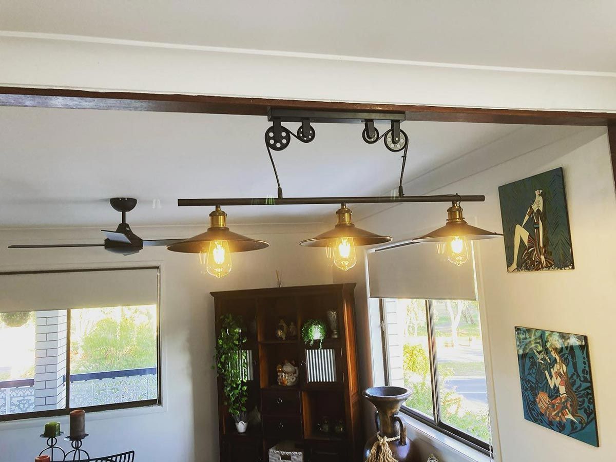 A Living Room With A Ceiling Fan And Three Lights Hanging From The Ceiling — AA Electrical Co in Yeppoon, QLD