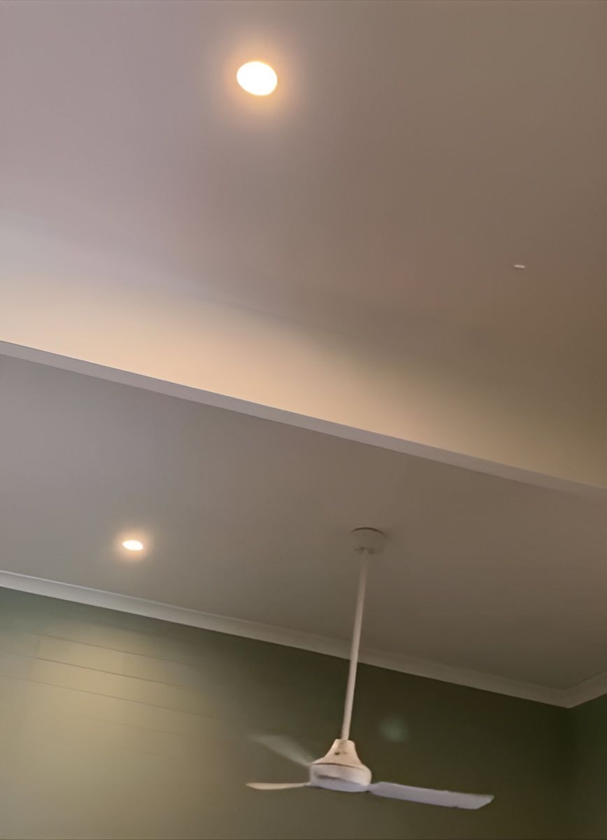 A White Ceiling Fan Is Hanging From The Ceiling Of A Room — AA Electrical Co in Yeppoon, QLD