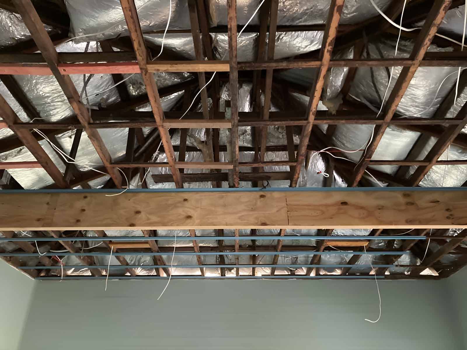 A Wooden Ceiling With A Lot Of Wires Hanging From It — AA Electrical Co in Yeppoon, QLD
