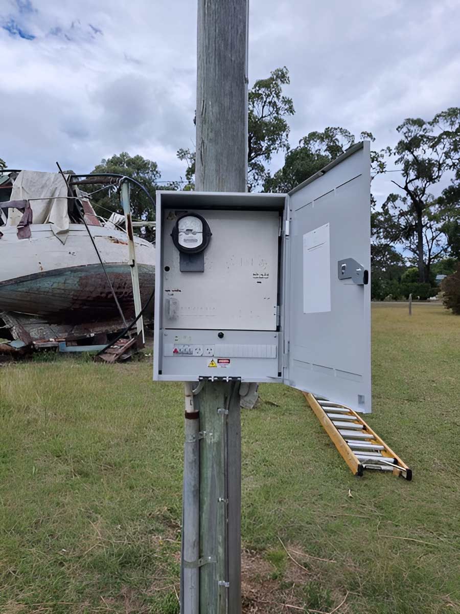 A Box Is Sitting On Top Of A Pole In A Field — AA Electrical Co in Yeppoon, QLD