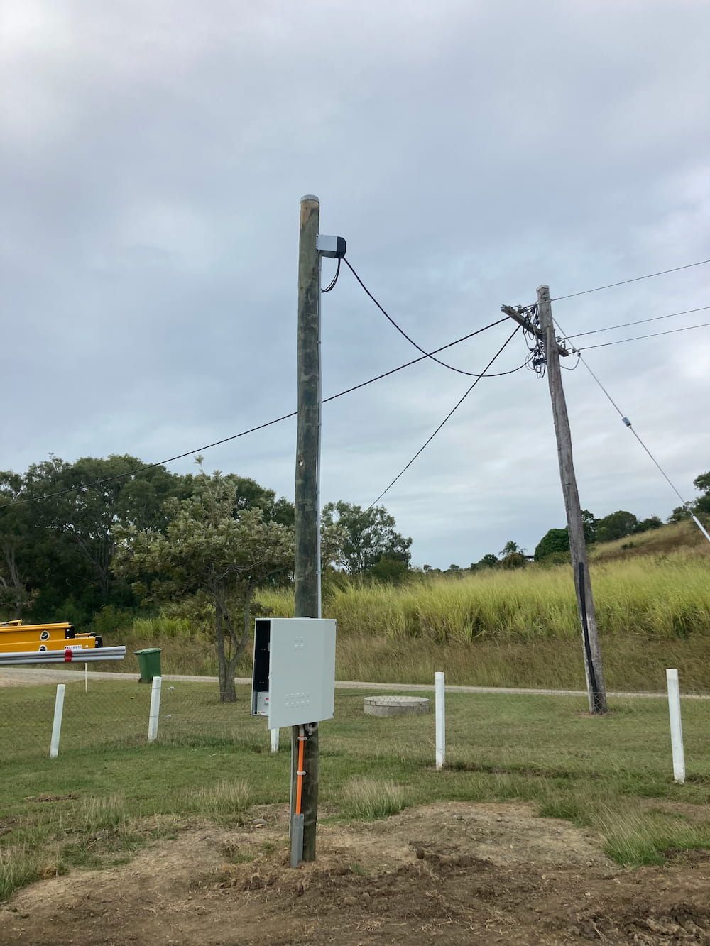 A Telephone Pole With A Box Attached To It In A Field — AA Electrical Co in Yeppoon, QLD