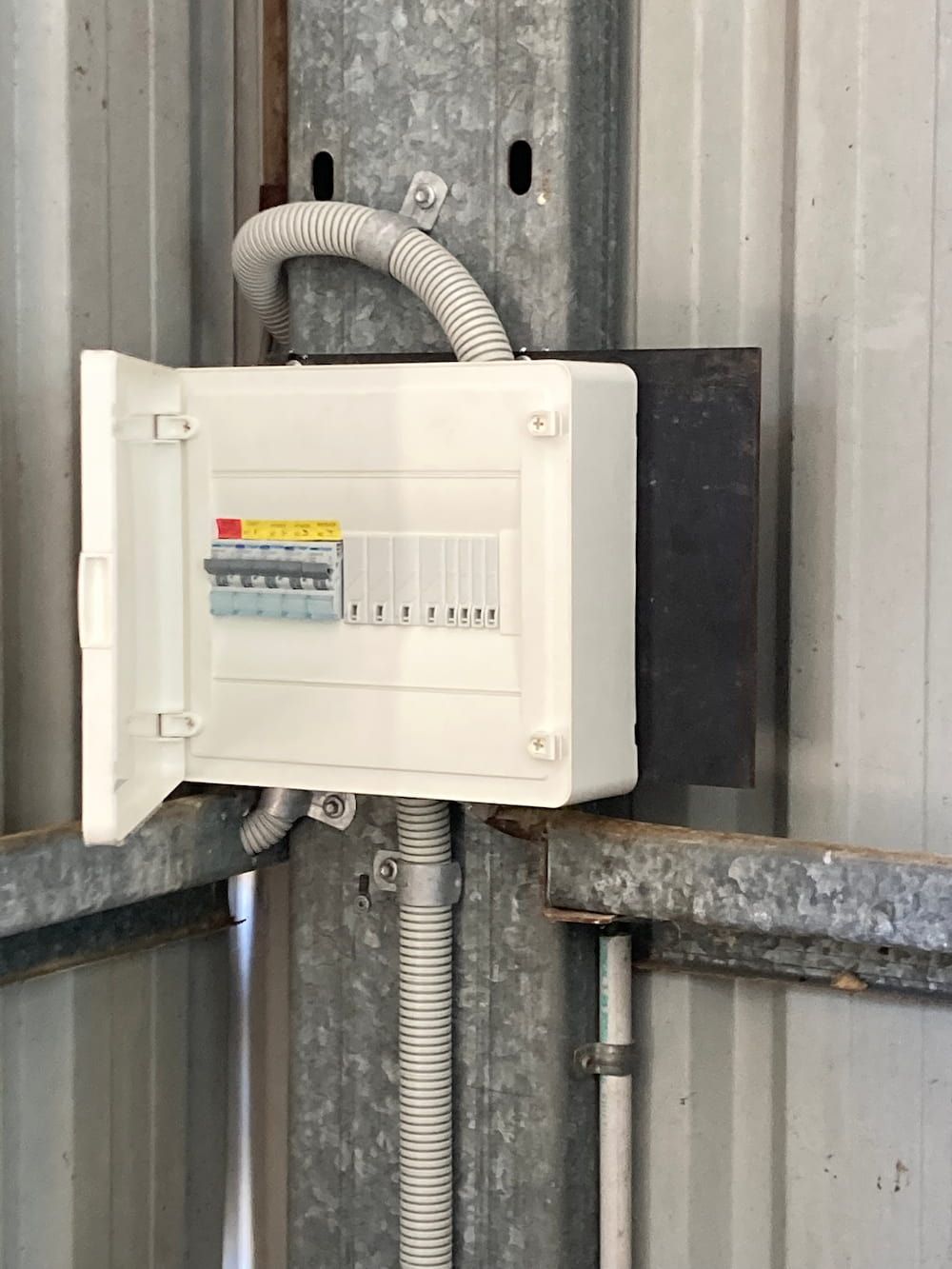 A White Box Is Hanging On A Metal Wall — AA Electrical Co in Yeppoon, QLD