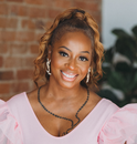 A woman in a pink dress and earrings is smiling for the camera A woman in a pink dress and earrings is smiling for the camera