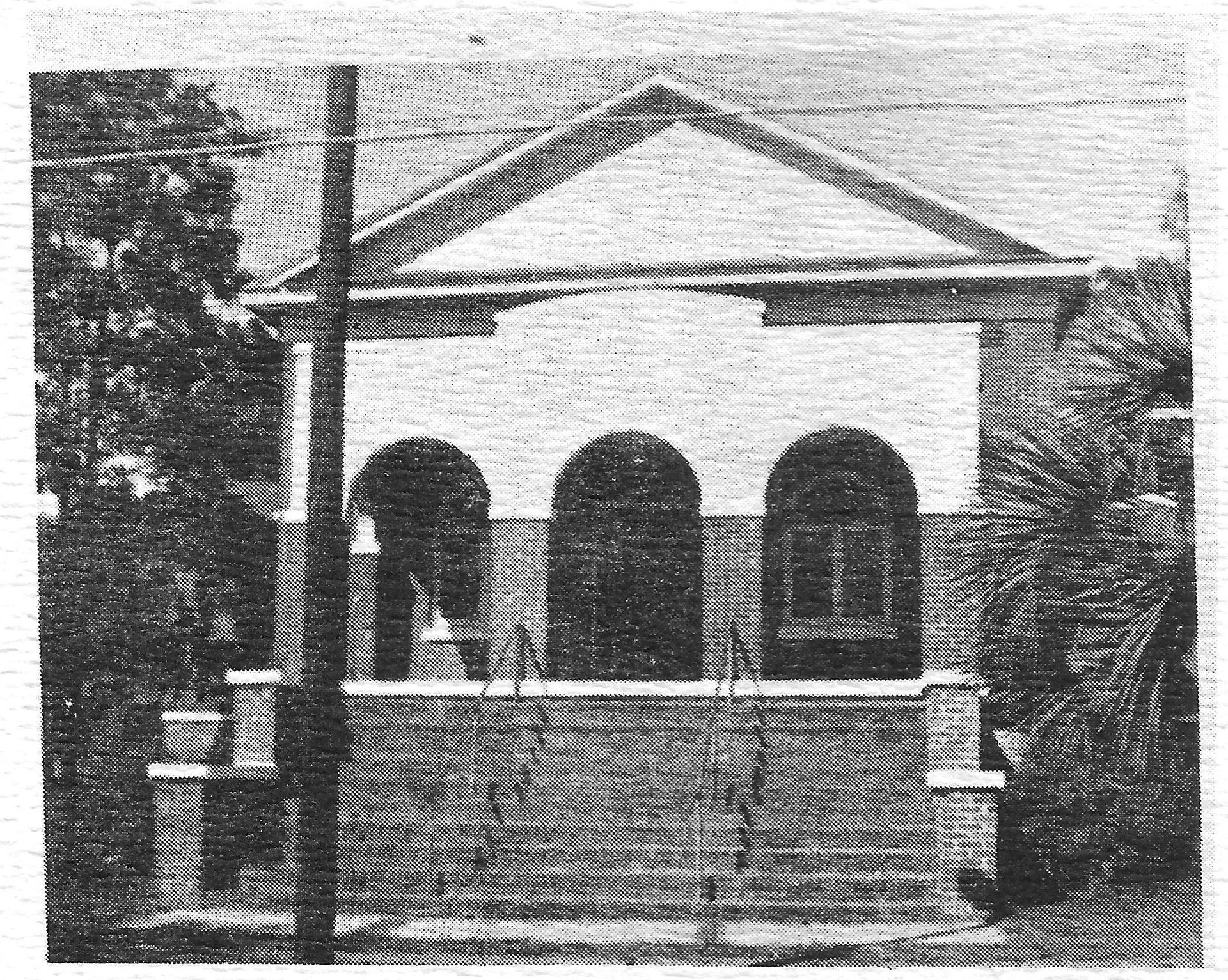 A black and white photo of a building with arches