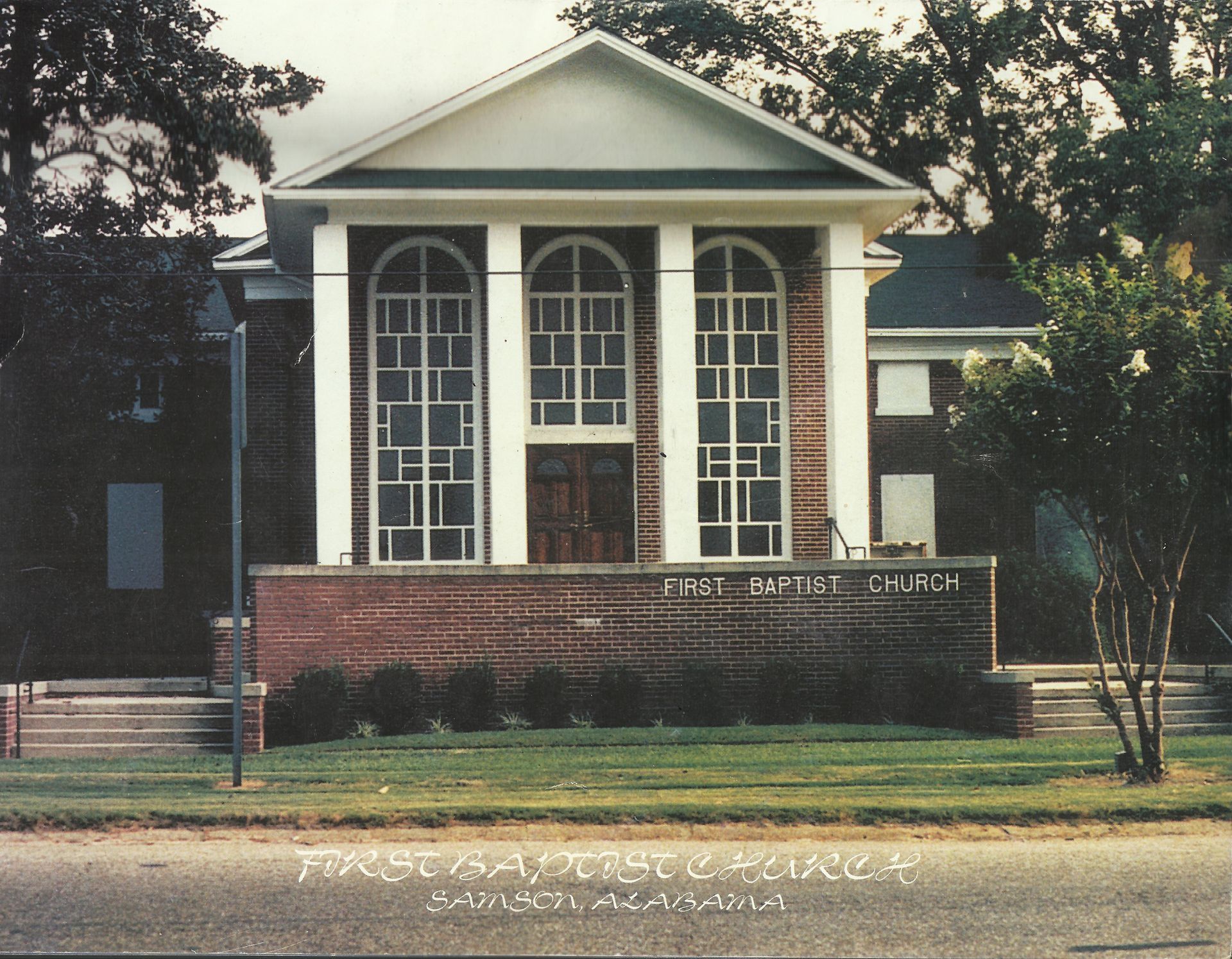 The front of a church with a sign that says first baptist church