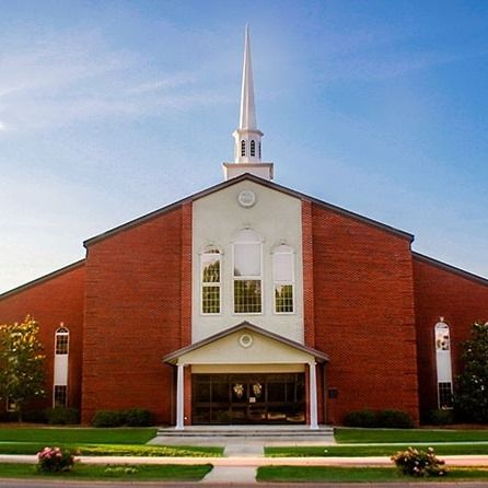 A large red brick church with a white steeple
