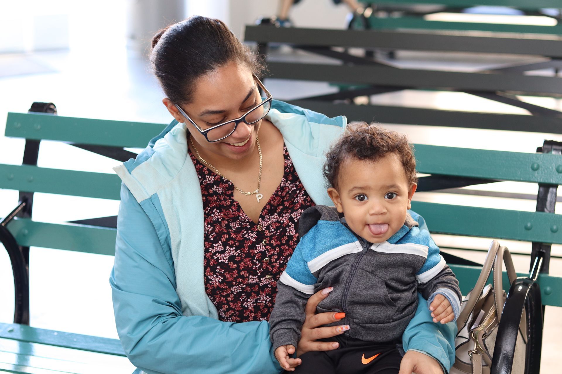 Mother holding young boy on lap on park bench.