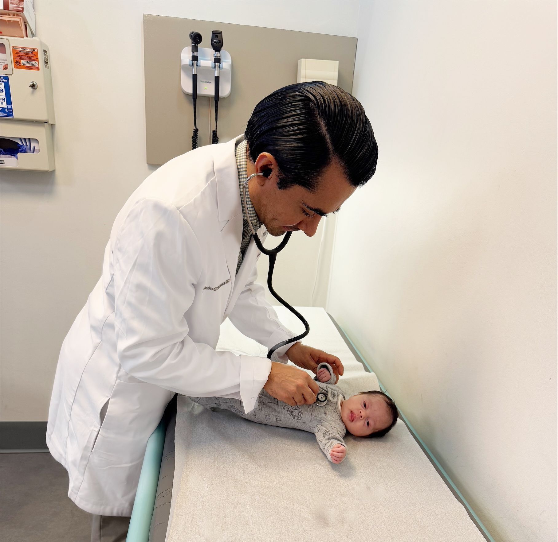 A doctor examines a baby with a stethoscope