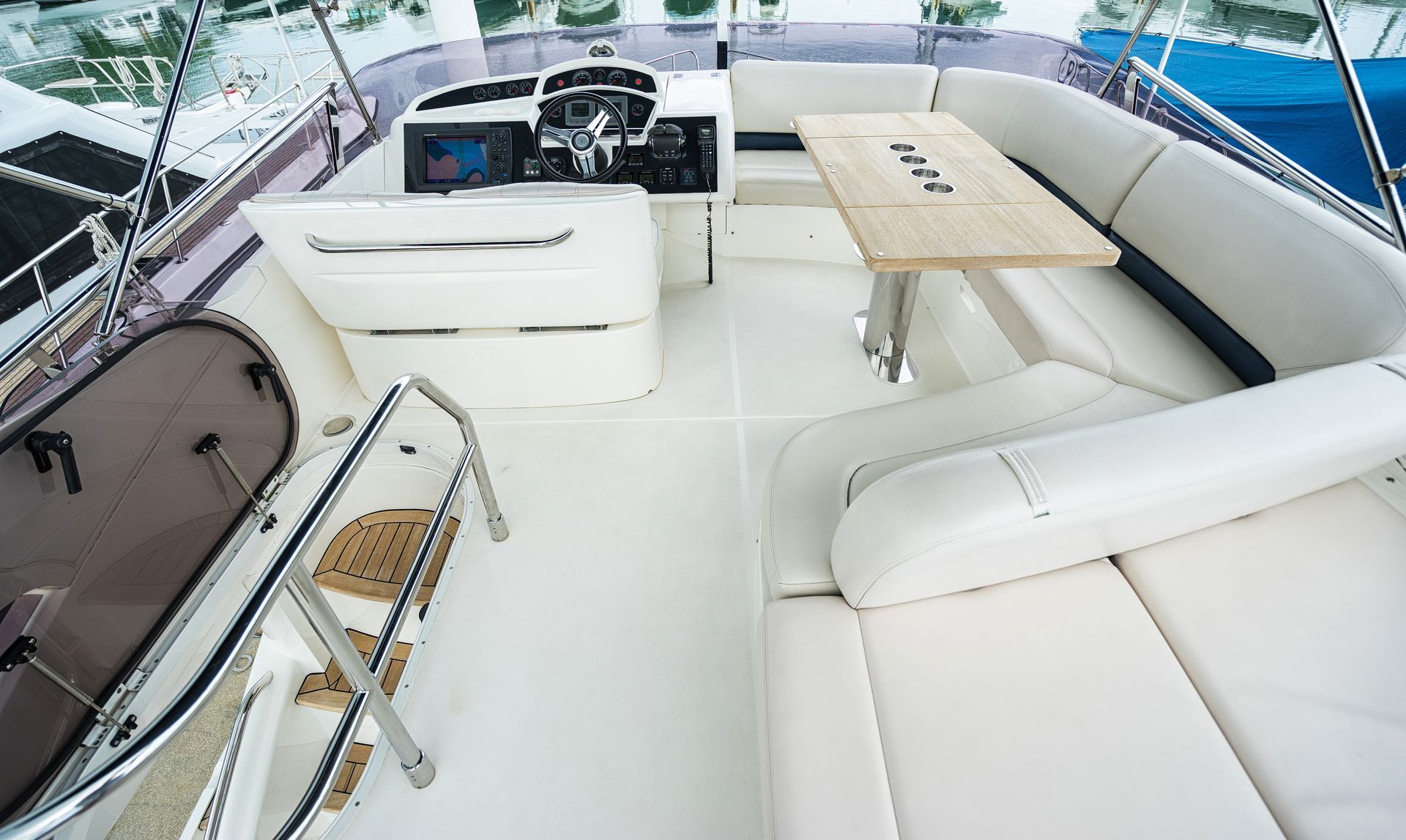 The inside of a boat with a table and a steering wheel