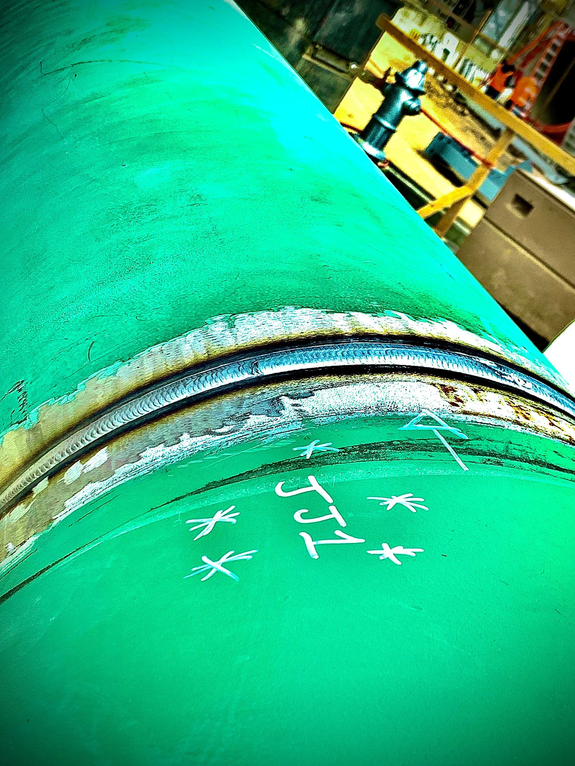 A close up of a green pipe with a drawing on it.