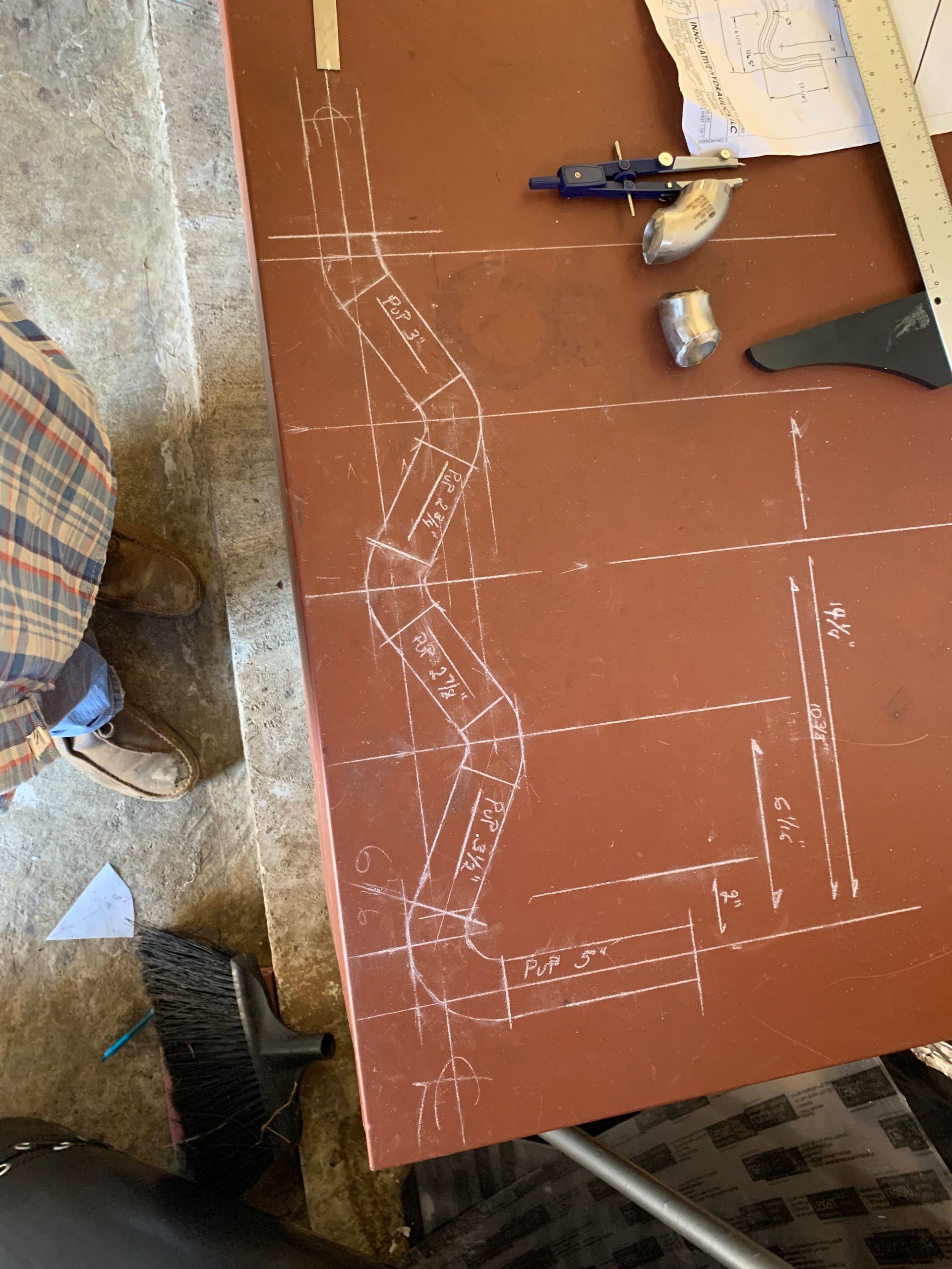 A person is sitting at a table with a drawing on it.