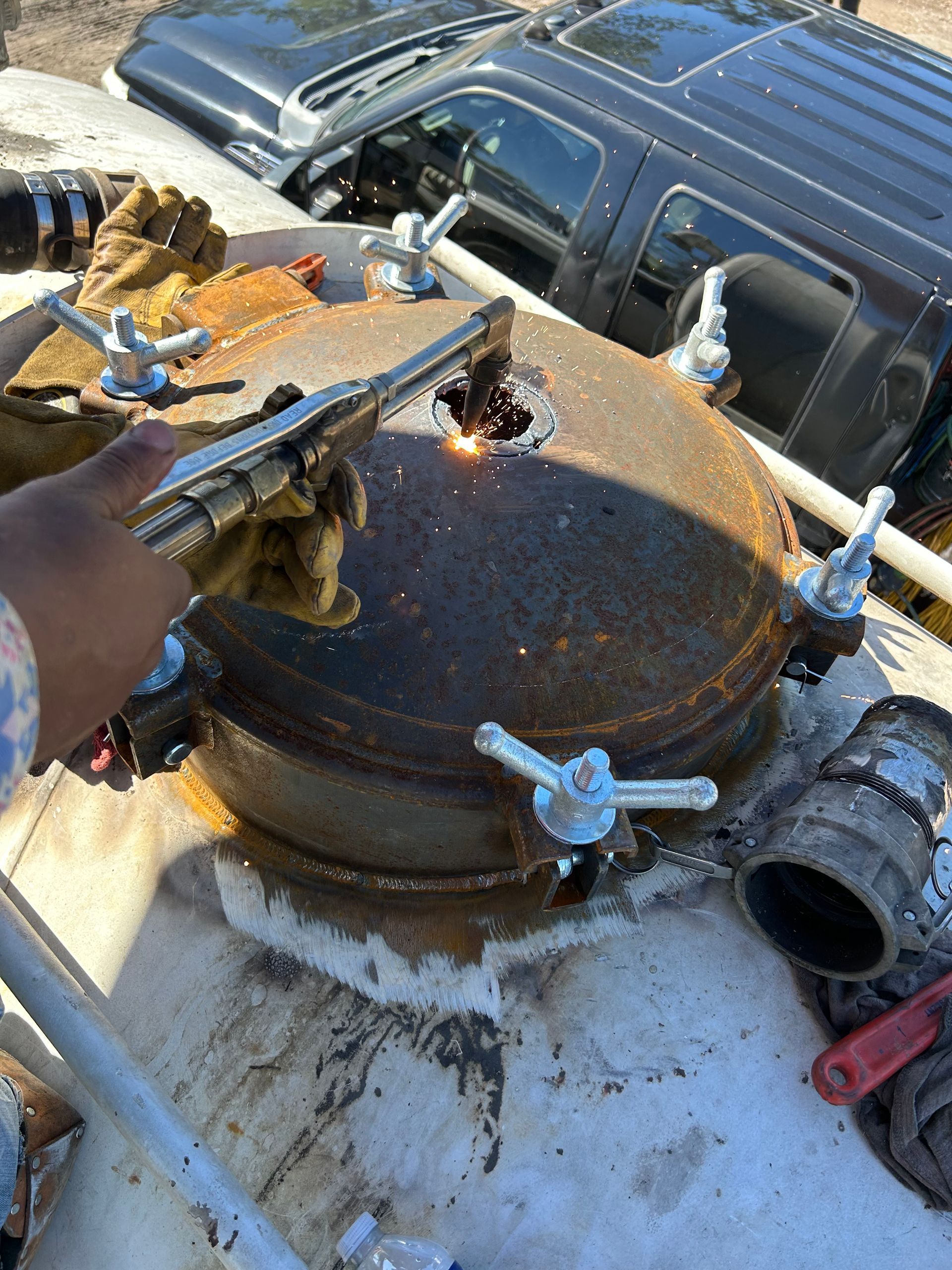 A person is welding a metal object with a welding torch.