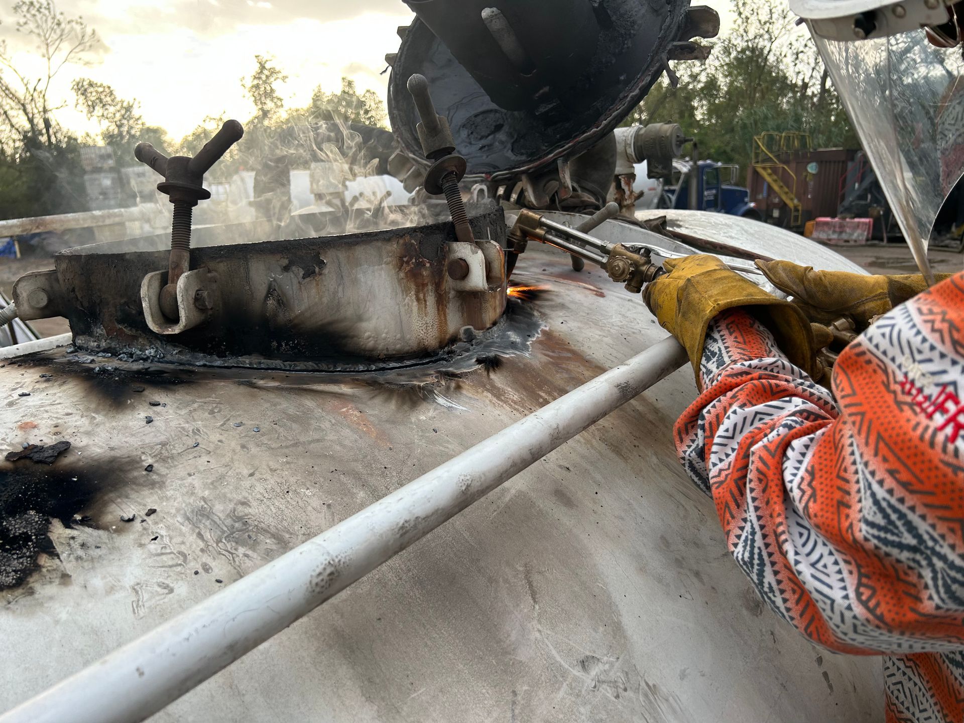 A person is welding a tank with a torch.