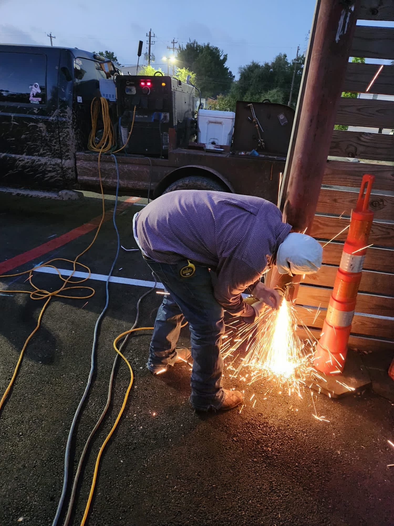 A man is cutting a piece of metal with a welding machine.