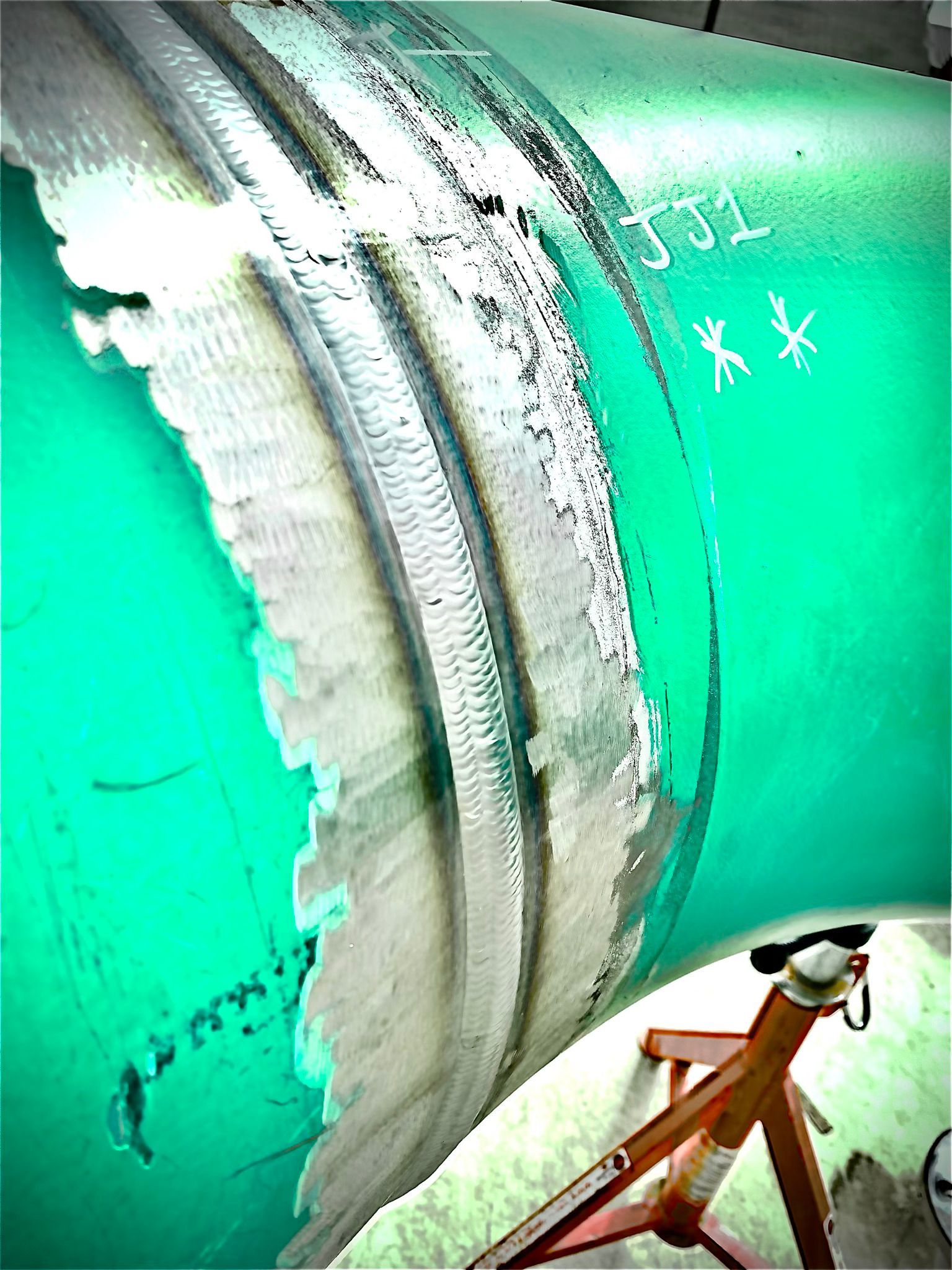 A green pipe with a hole in it is being repaired.