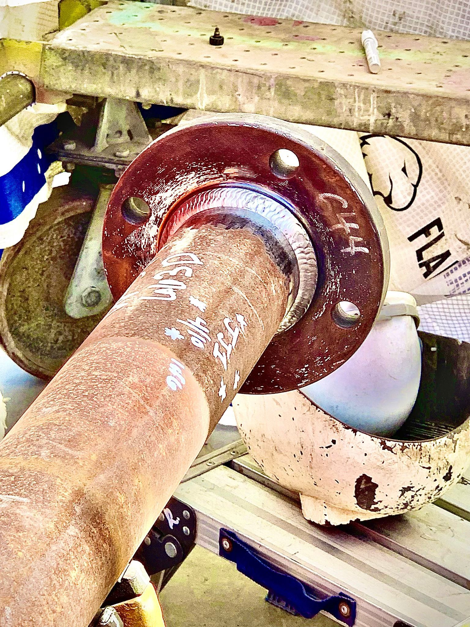A rusty pipe is sitting on top of a wooden table.