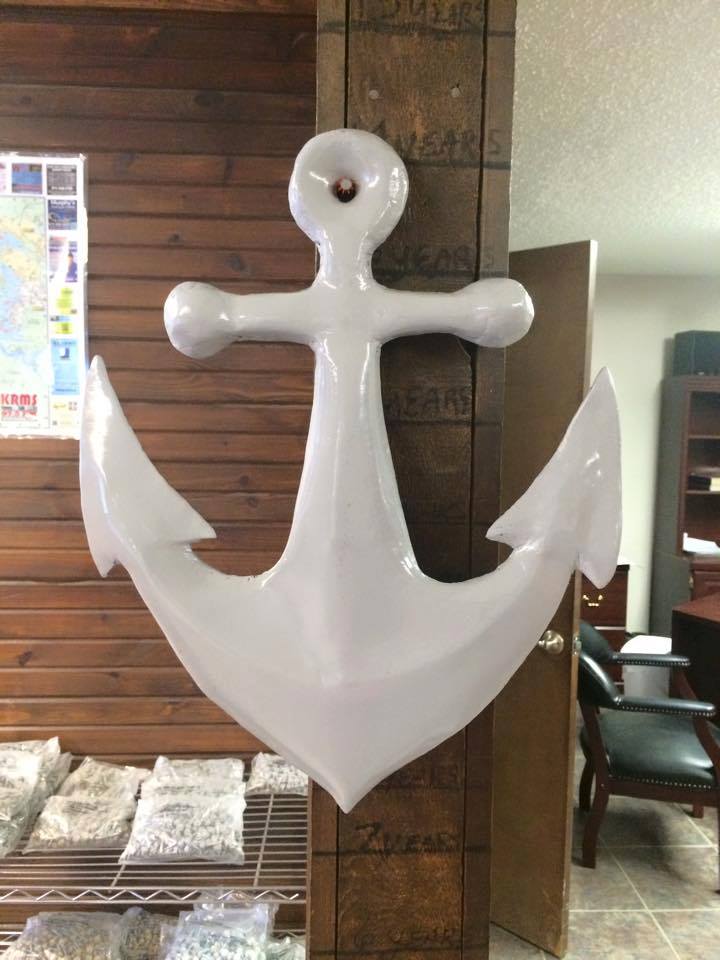White anchor mounted on a wooden wall indoors