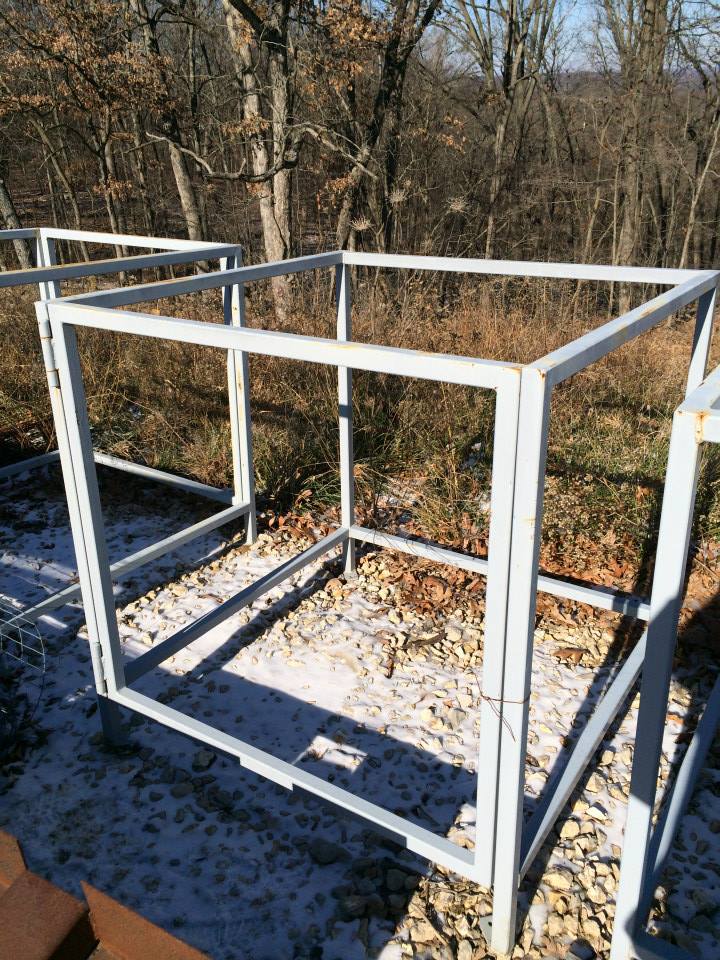 White metal cube frame outdoors on a snowy, wooded hillside