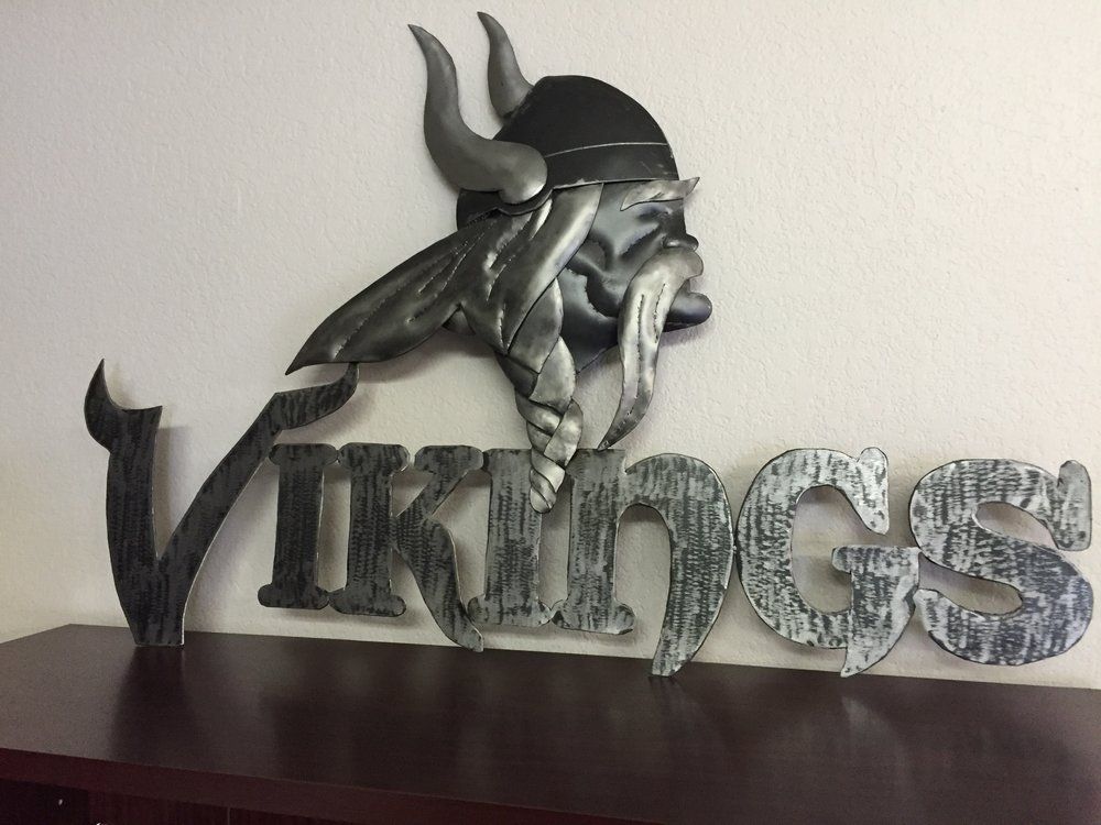 Decorative Viking helmet sculpture with the word “Vikings” on a shelf